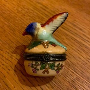 Small ceramic box with the lid adorned by a little bird. 2” tall x  1.5” high